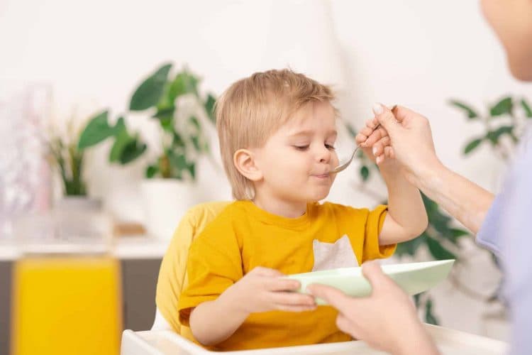 Little boy eating with spoon
