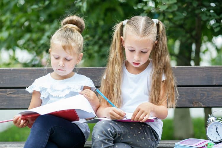 Attentive children draw in the schoolyard. The concept of school, study, education