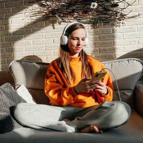 Happy woman listening podcast from mobile phone