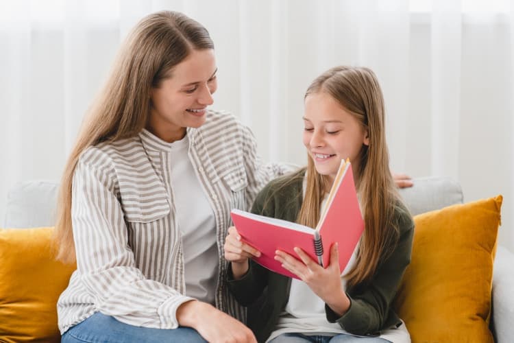 Mother and daughter talking on sofa. Schoolgirl showing her mom school marks, test results, diary.