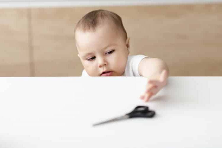 boy grabbing scissors