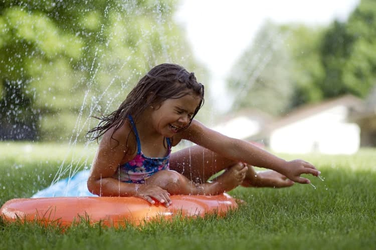 Sliding on a slip and slide outside, kids being kids, water and movement.
