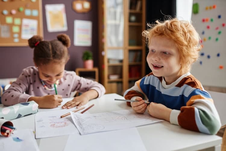 Cheerful cute learner of kindergarten with freckles and red hair