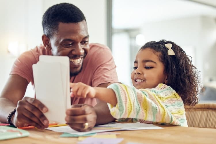Home school, learning and father helping his child with flash cards, homework or studying. Educatio