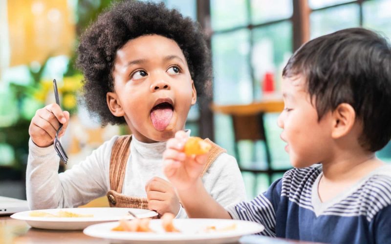playful kids eating snack in cafe restaurant
