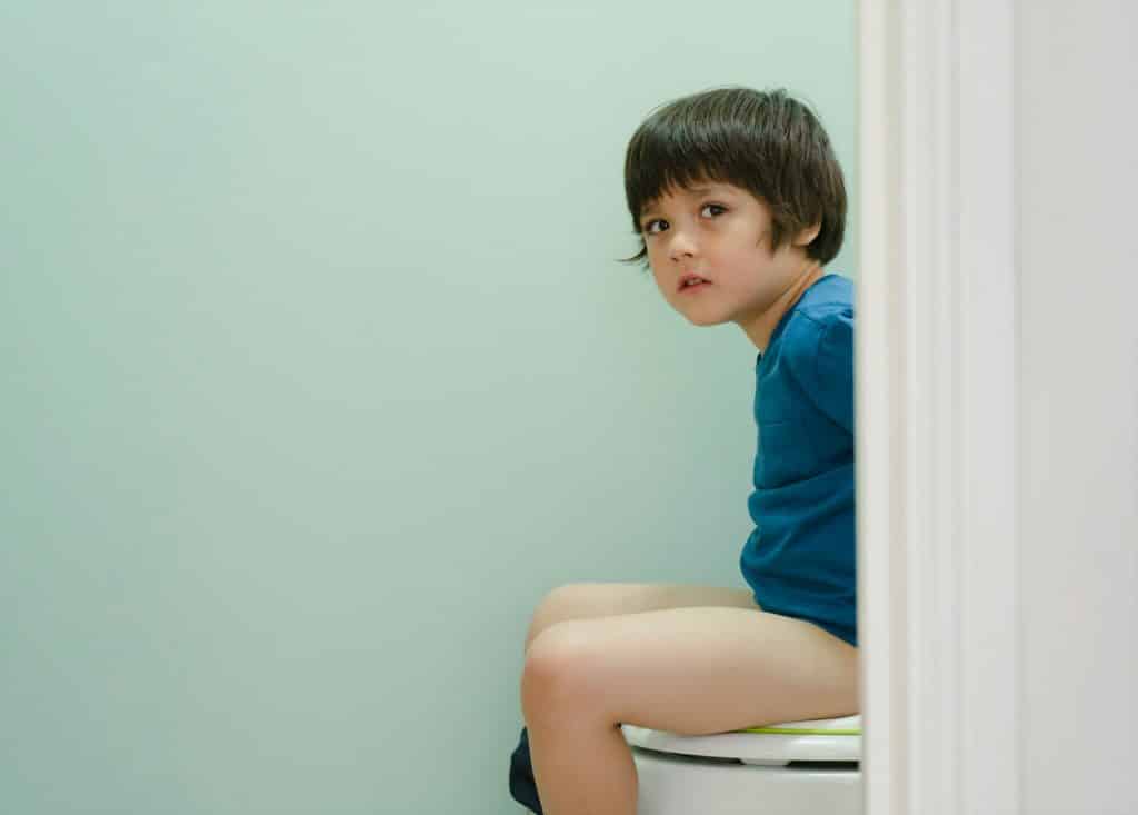 Unhappy Kid sitting on toilet with his stomach ache, Child boy trainig how to use toilet at home,
