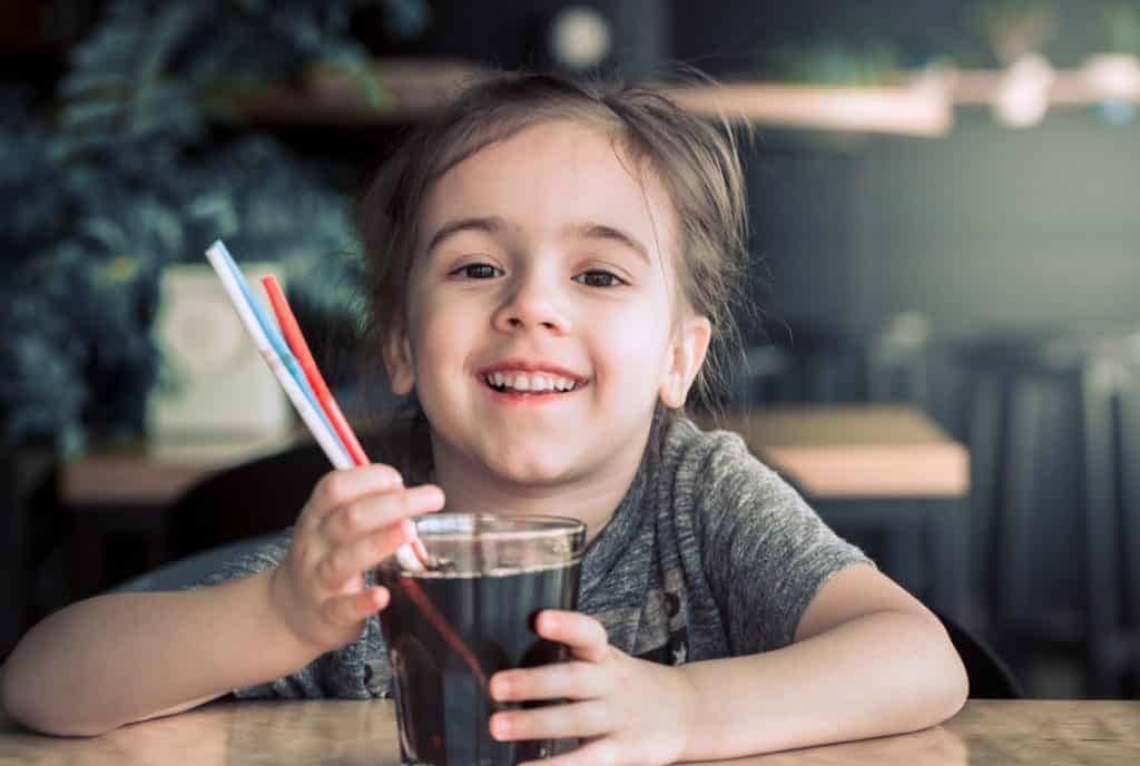 a child drinks a drink from a straw