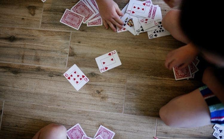 Kids playing cards on the floor at home
