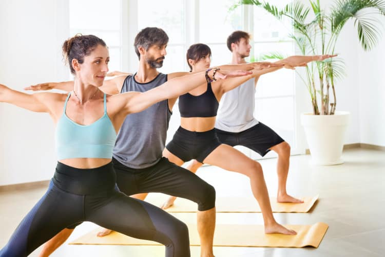 Group of people in warrior yoga pose