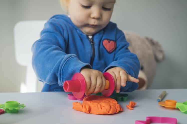Baby girl playing with modeling clay