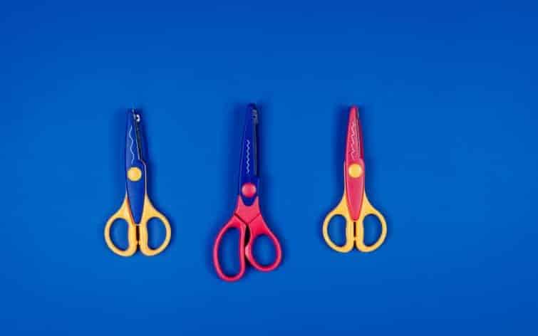 different scissors for children's creativity on blue paper background