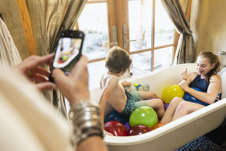 Two children and balloons in a bathtub