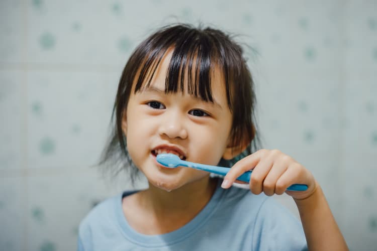 kid brushing teeth for tooth and gum hygiene