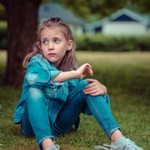 selective focus photography of girl sitting near tree